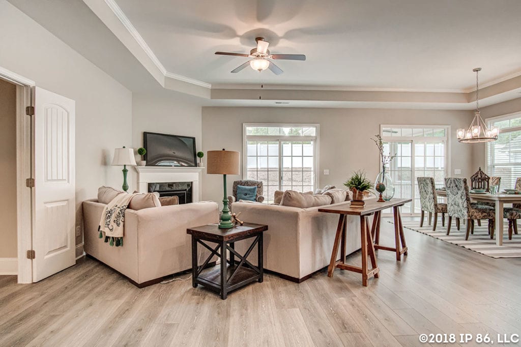 A bright and open living space with hardwood floors, crown molding and stylish furniture.