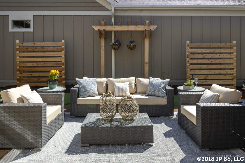 A comfortable outdoor space with a cushioned couch set, wicker table and rustic wood decor.